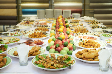 Catering table set service with cold snacks, canapes, fruits and