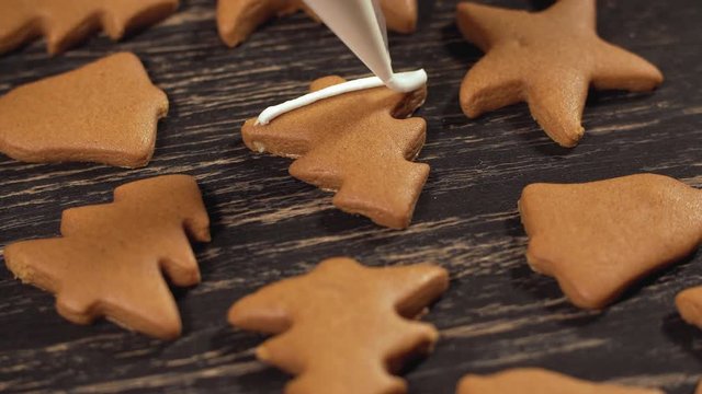 Close up garnishing homemade gingerbread christmas tree. Decoration process of Christmas cookies. Family culinary and traditions concept