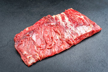 Raw wagyu bavette de flanchet steak offered as top view on a black board