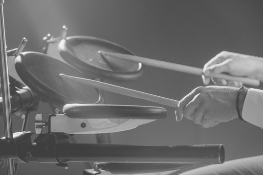
Drummer. The guy holds drum sticks in his hand against the background electronic drum. Young man with drum sticks. 