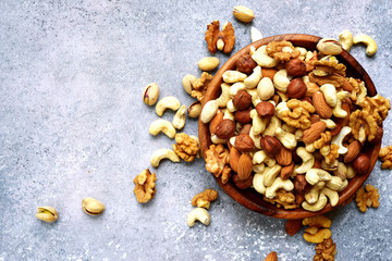 Wooden bowl with nuts ( pistachio, walnut, hazelnut, cashew, almond) .Top view with copy space.