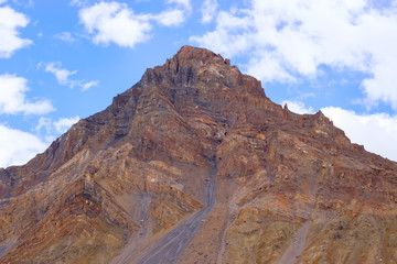 Alpine peak against the blue sky with clouds.