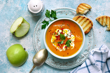 Vegetarian pumpkin carrot soup with apple and ginger in a vintage bowl.Top view with copy space.
