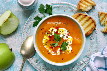 Vegetarian pumpkin carrot soup with apple and ginger in a vintage bowl.Top view with copy space.