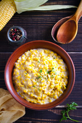 Sweet and creamy corn in bowl. Corn dish. overhead, vertical