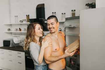  beautiful couple in the kitchen take food out of the fridge