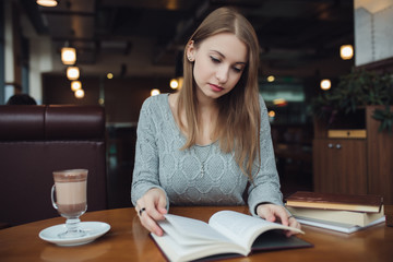 Woman reading book in the cafe