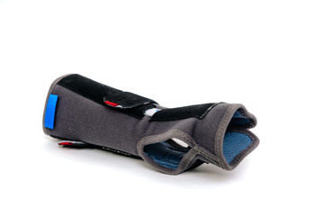 Gray-black orthosis on white, isolated background. Protective wrist brace stiffens the hand, joints during injury. Replacement of gypsum and splint with orthosis. Help with hand injuries. Hand pain.