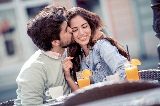 Couple in love in cafe laughing and hugging