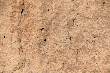 Ancient petroglyphs carved in the face of a cliff at Bandelier National Monument near Santa Fe, New Mexico