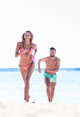 Romantic couple walking on beautiful tropical beach.