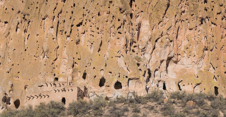 Panorama of abandoned ancient cliff dwellings and caves in a colorful cliff face in Bandelier National Monument near Santa Fe, New Mexico