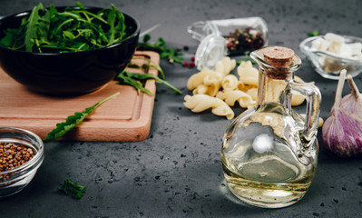 Arugula in a black, large bowl. Green, fresh arugula in a bowl on a wooden stand and a stone counter. The concept of preparing a fresh and healthy salad. Healthy nutrition, taking care of health.