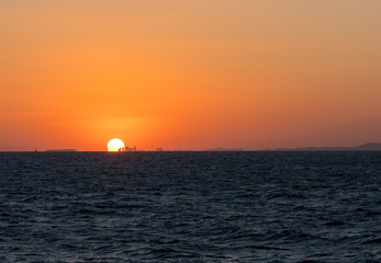Sun setting behind the tall city skyline of Qingdao
