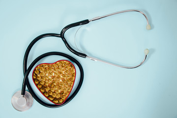 A heart-shaped box with tablets inside and a stethoscope. Medical concept, care for the heart,...