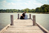 Rear view couple sitting on pier