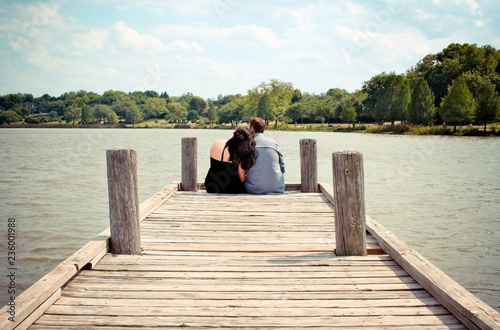 Rear view couple sitting on pier