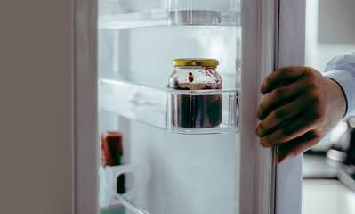 The man pulls food out of the fridge. View of the open fridge. Using the fridge, cooling the food...