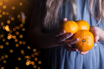 girl holding tangerines