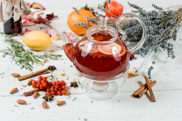 glass teapot transparent with hot red tea with oranges and cinnamon and spices