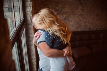 Couple hugging near the window