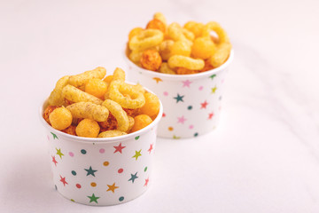 Assorted puff corn snacks in two paper cup