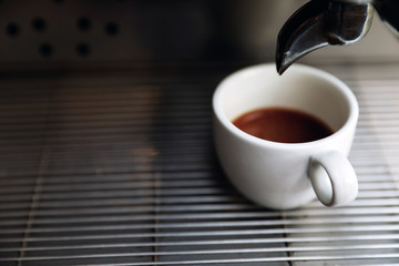 Modern coffee machine with cup on drip tray, closeup. Space for text