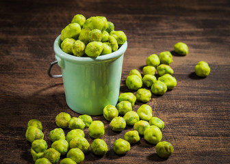 Homemade Dry Spice Wasabi Peas as an Appetizer on a dark wooden background.