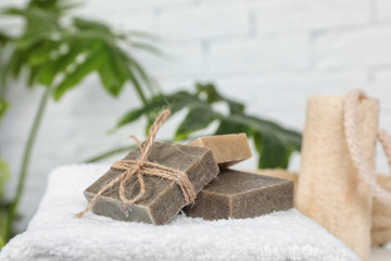 Handmade soap bars on white towel against blurred background