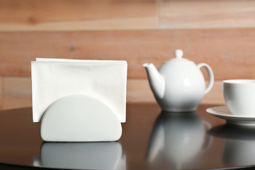 Ceramic napkin holder with paper tissues on served table. Tea time