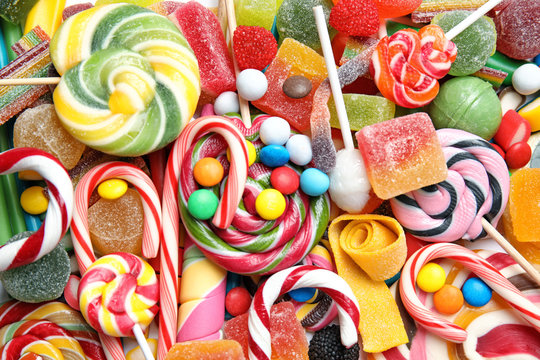 Many different yummy candies as background, top view
