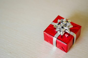 A red gift box on a wooden table. 