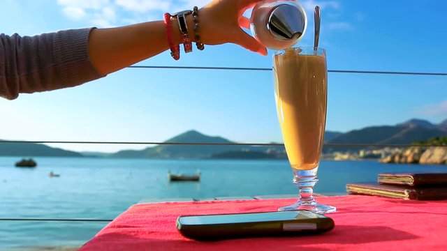 Young woman drinking instant coffee in the beach bar