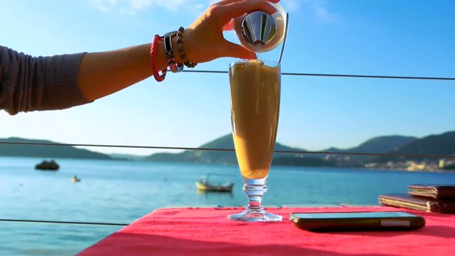 Young woman drinking instant coffee in the beach bar