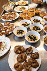 Group of plates with soups of various types in hot bowls.