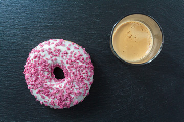 Top view of white glazed donut with sprinkles and a coffee