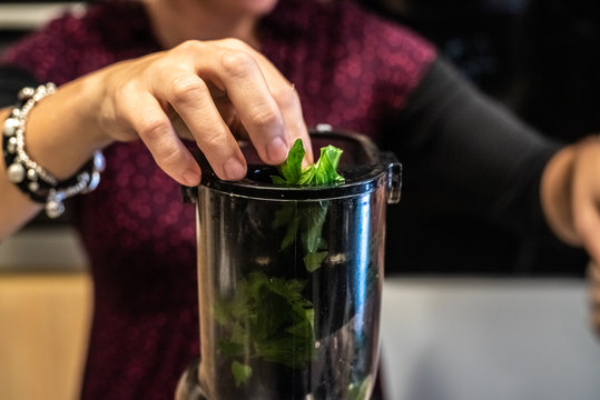 Woman Preparing A Healthy Green Juice In A Blender.