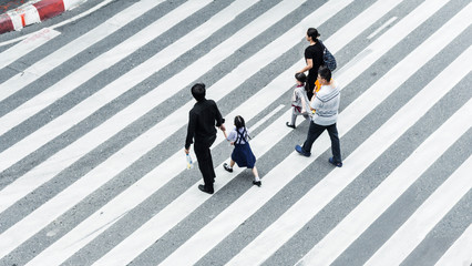Crowd of people and group of family with child walk on street pedestrian crossroad in the city...