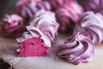 Close up of homemade cut pink zephyr or marshmallow in powdered sugar on wooden
