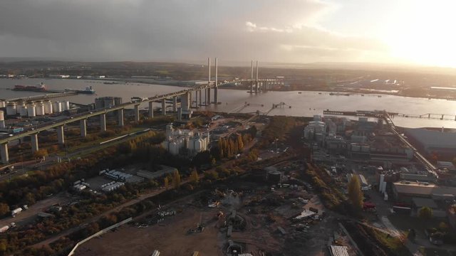 An aerial view of the traffic coming out of the tunnel at Dartford Crossing and going up the Queen Elisabeth II bridge at sunset