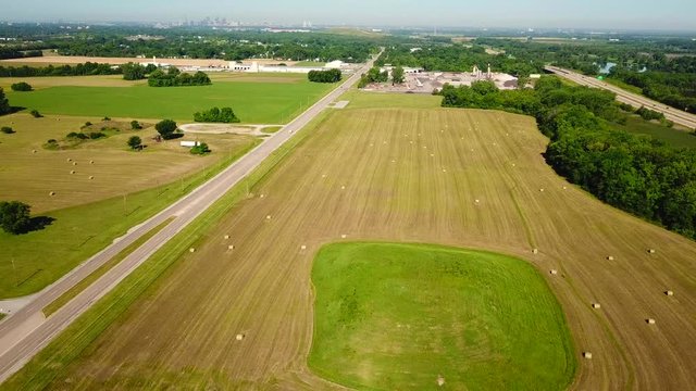 Reverse view of a small mound sour rounded by Haystacks and a view of the city of ST. Louis