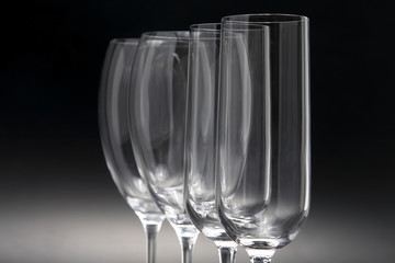 Four wine glasses on a dark background close-up