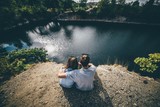 Rear view of couple sitting on rock