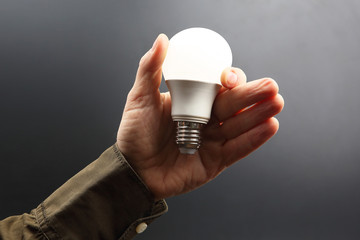 Included led new lamp in human hand on dark background