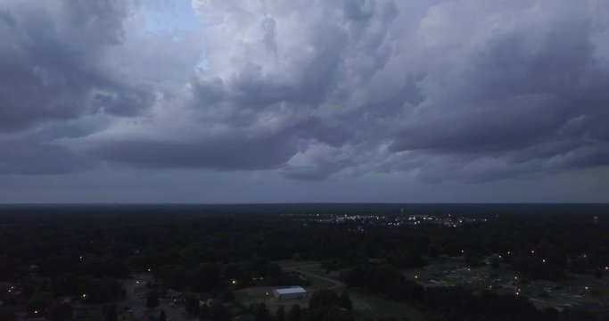 Dark storm clouds rolling in over small town, drone angle