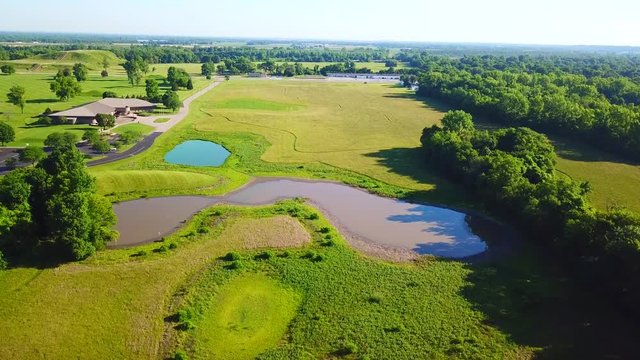 Forward view over a green pond and a muddy pond.