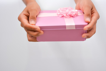 Obraz premium pink gift box in girl hands isolated on white background. can used for the holidays present.