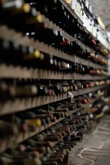 Rows of wine bottles collecting dust in Italian wine cellar