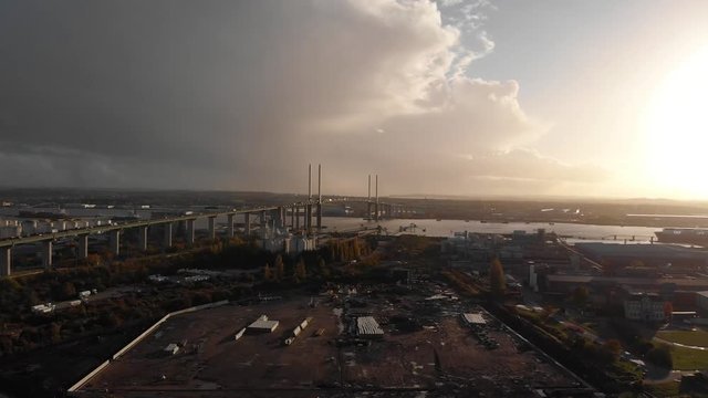 Rising shot over an industrial lot near Queen Elisabeth II bridge, Dartford crossing at sunset
