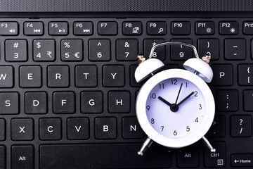 clock on keyboard concept for time management and countdown to deadline